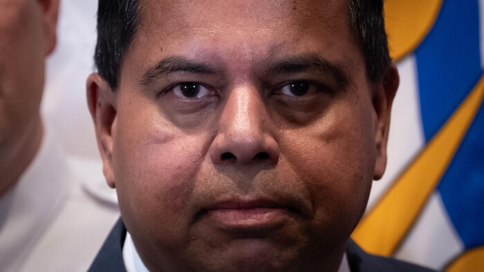 Plan rapproché du visage de Gary Anandasangaree, qui regarde fixement, d'un air sérieux, l'objectif de la caméra.