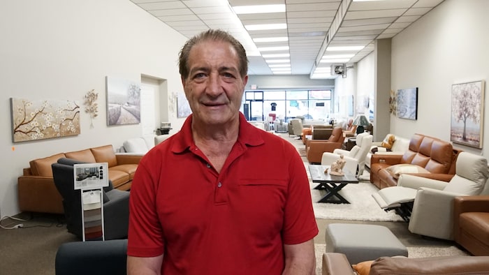 Gary Robicheau est à l’intérieur de son magasin rempli de meubles.
