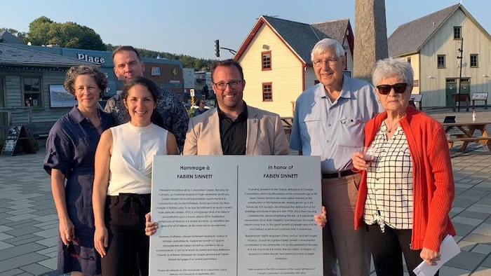 Le maire de Gaspé Daniel tient la plaque honorifique de Fabien Sinnet. Il est accompagné de Fabien Sinnett et de sa famille, et de la directrice générale du Berceau du Canada.