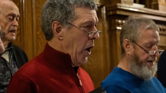 Un homme chante dans une chorale.