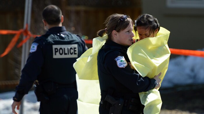 Une policière avec un enfant dans ses bras.