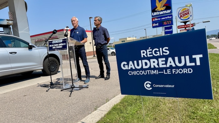 Le candidat du Parti conservateur du Canada pour l’élection partielle dans Chicoutimi–Le Fjord, Régis Gaudreault, et le lieutenant politique du PCC, Pierre Paul-Hus, se tiennent debout dans un stationnement.