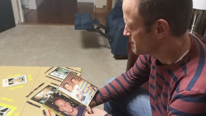 Cory Baylis regarde une photo de son frère dans un cadre.