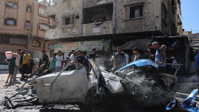 Des résidents tentent d’éteindre un incendie à la suite d’une frappe aérienne israélienne qui a touché un véhicule.