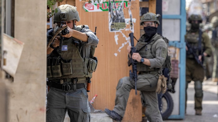 Un soldat de l'armée israélienne pointe son fusil lors d'une opération militaire israélienne.