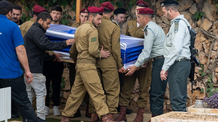 Des soldats portent un cercueil. 