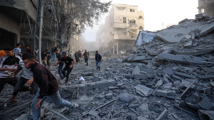 Des personnes courent se mettre à l'abri après un bombardement, le 19 octobre 2025.