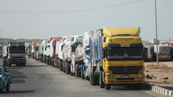 Des camions d'aide attendent en ligne. 