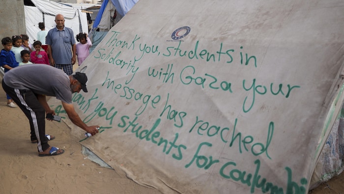 Un homme à Rafah écrit un message de remerciement aux étudiants manifestants aux États-Unis, le 27 avril 2024.