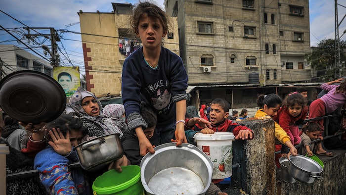 أطفال فلسطينيون نازحون يتجمعون للحصول على الطعام في نقطة توزيع في رفح في 24 شباط (فبراير) 2024.