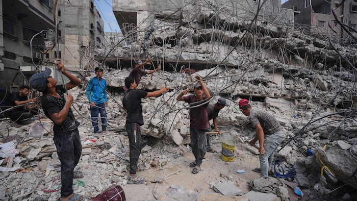 À Gaza, le 16 août 2026, des Palestiniens récupèrent du fer dans les décombres des bâtiments détruits par les frappes aériennes israéliennes, afin de le réparer et de le recycler pour la construction, la fabrication de tentes ou la revente.