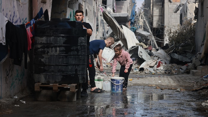 Des enfants palestiniens remplissent des récipients d'eau dans la bande de Gaza.