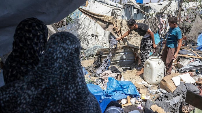 Des Palestiniens déplacés inspectent les dégâts sur le site d’une frappe israélienne contre une tente.