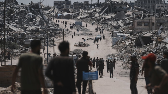 Des déplacés palestiniens marchant au milieu de ruines à Gaza, le 4 juin 2025.