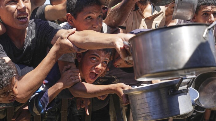 Des Palestiniens se battent pour recevoir de la nourriture.