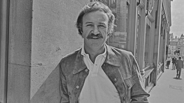 Un homme qui porte une moustache sourit.