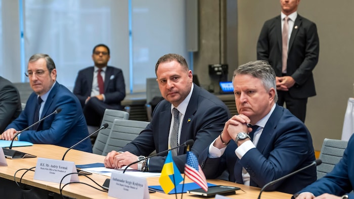 Des hommes discutent à une table.