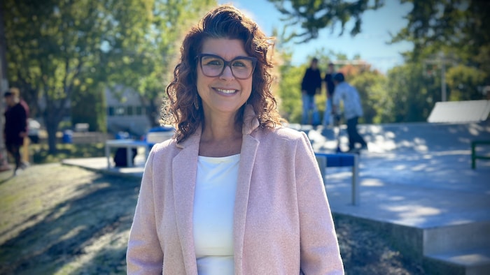Geneviève Dubois, à l'extérieur, sourit à la photographe.