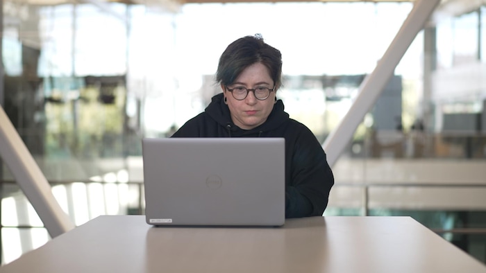 Une femme travaille sur un ordinateur sur un bureau.