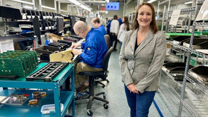 dame debout face à l'objectif dans une usine