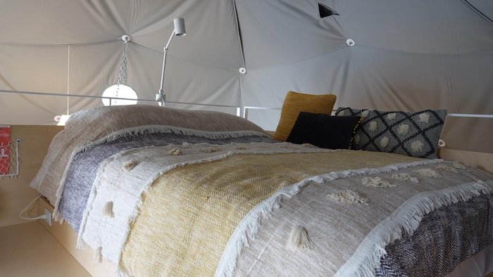 Un lit avec un couvre-lit et des coussins style boho.