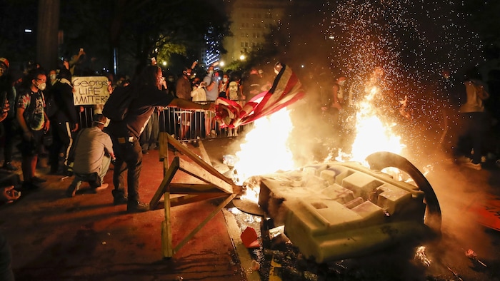 Des manifestants devant des barrières en feu