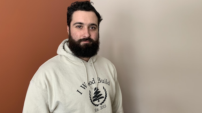 George Laskaris porte un chandail blanc