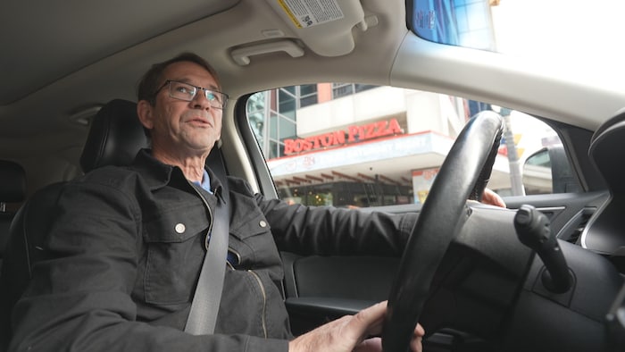 Un homme au volant de sa voiture.