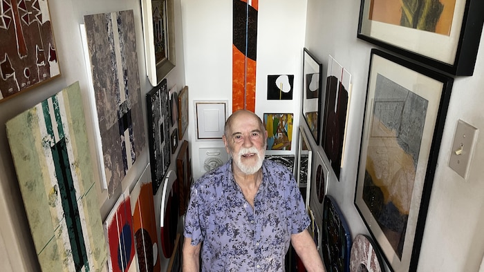 Un homme entouré d'œuvres d'art.