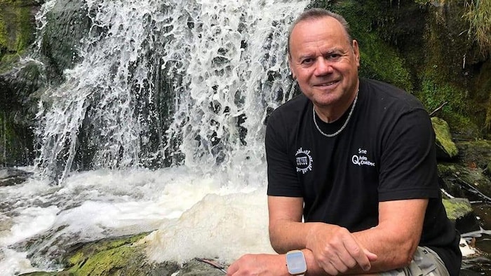 Un homme devant une chute d'eau