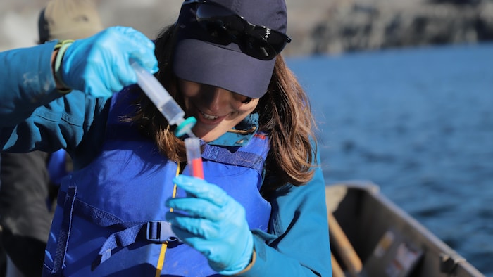 Mariana Goldoni récolte un échantillon d'eau qui sera analysé en laboratoire.
