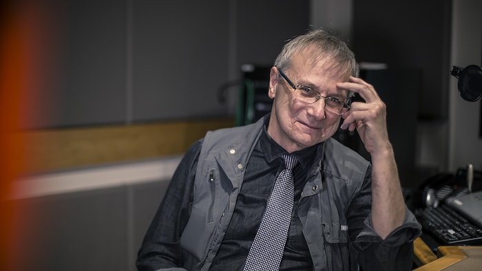 Gérard Delisle attablé dans un studio de Radio-Canada Ottawa-Gatineau.