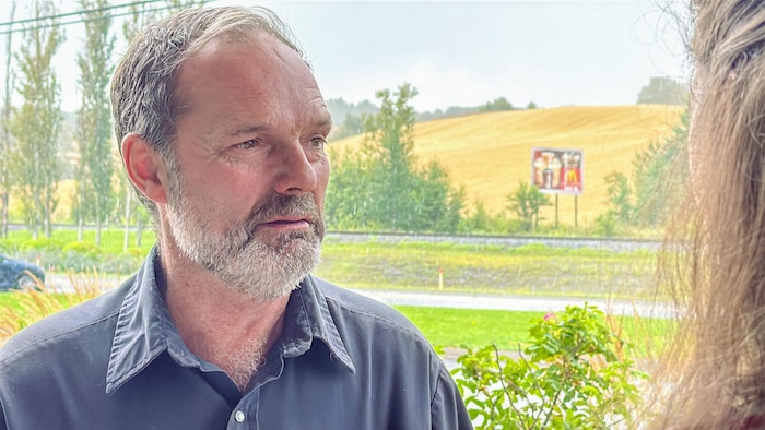 Portrait de Germain Michaud s'adressant à une journaliste.