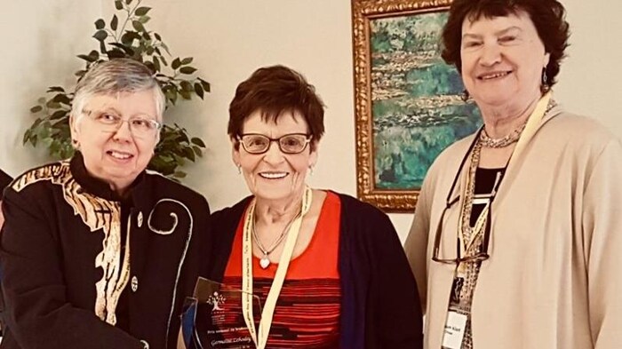 Trois femmes aînées posent avec le prix remis à Germaine Lehodey.