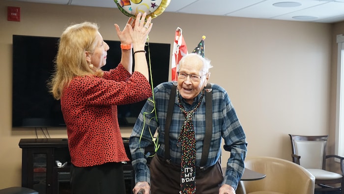 Gerry Wagner, un vétéran de la Seconde Guerre mondiale, à droite, en chemise à carreaux et la députée France Gélinas, à gauche, en rouge. 