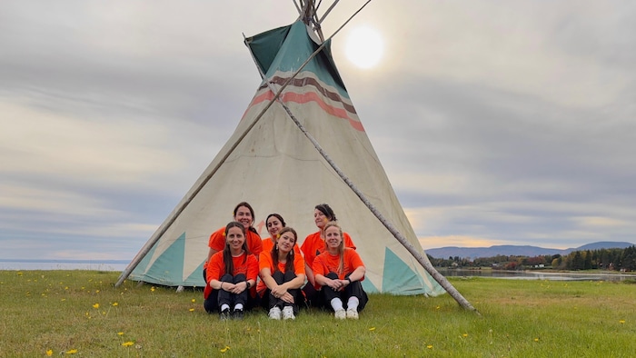 Photo d'équipe devant un tipi à Gesgapegiag.