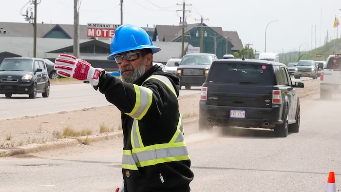 Un homme régule la circulation sur l'autoroute 63.