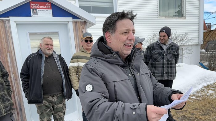 Ghislain Collin tient une feuille.