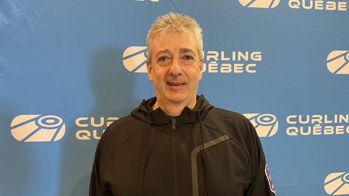 Ghislain Doyon est debout dans une salle pour se faire prendre en photo. 