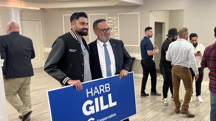 Harbinder Gill et un partisan, pancarte dans les mains.