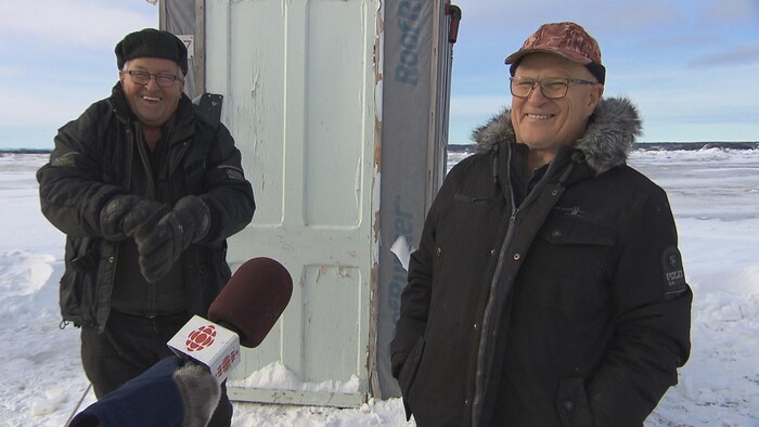 Deux hommes souriant à la caméra.