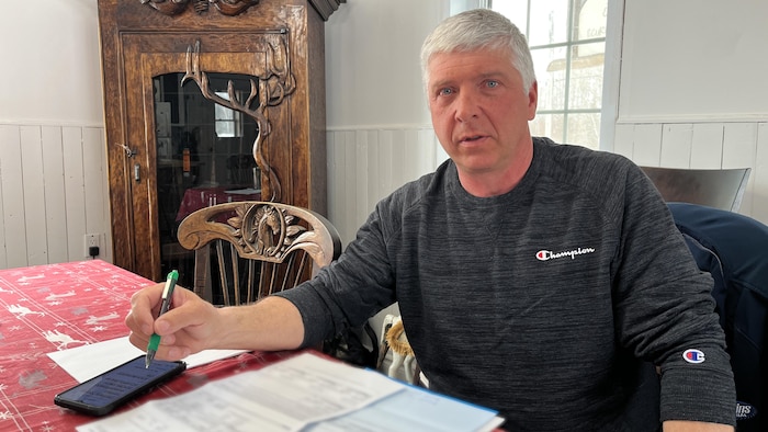 Gilles Vallée devant ses documents de taxes dans sa cuisine.