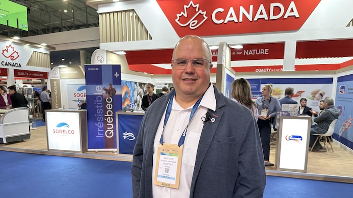 Gino Cyr devant le kiosque présentant les produits marins du Canada.