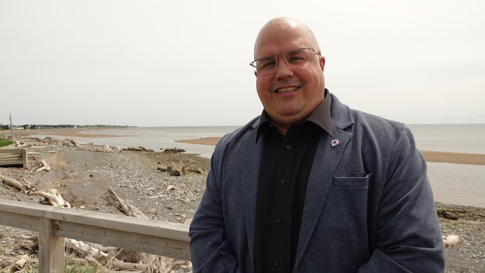 Gino Cyr en veston sur une plage.