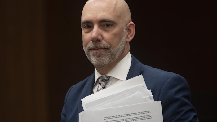 Le directeur parlementaire du budget, Yves Giroux, tient des documents.