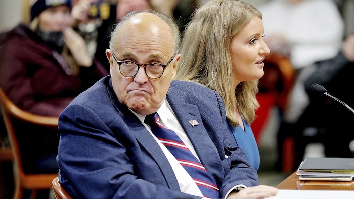 Rudy Giuliani, assis au côté d'une autre avocate du camp Trump, se retourne et inspecte la salle durant une audience visant à mettre en doute les résultats du vote au Michigan, le 7 décembre 2020.