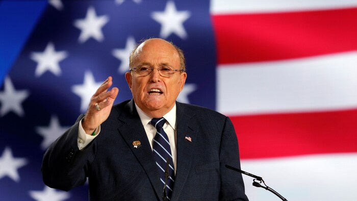 Rudy Giuliani prend la parole devant un drapeau américain.
