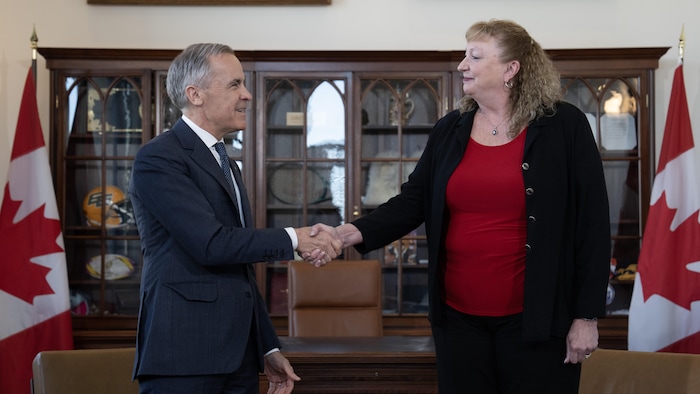 Marylin Gladu et Mark Carney se serrent la main.
