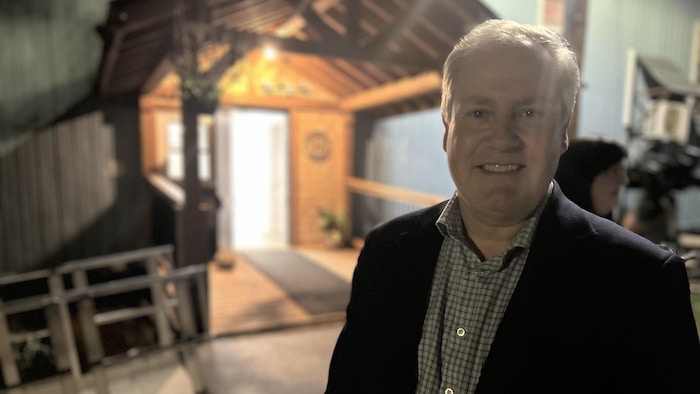Le chef progressiste-conservateur Glen Savoie, devant un bâtiment. 