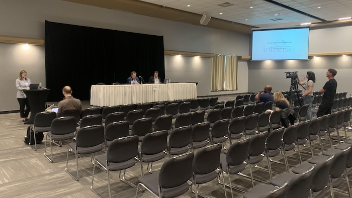 Quelques personnes assistent à une conférence de presse.